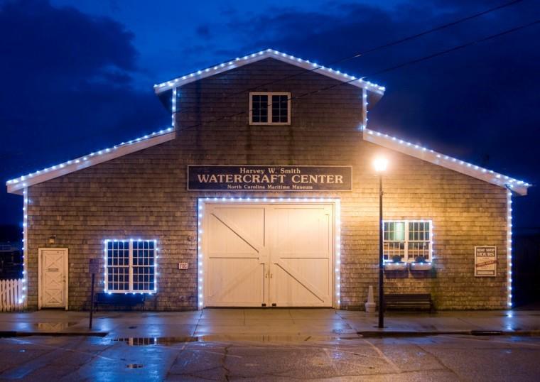 view of the watercraft center from Front Street at night with lights lining the building edges and frames 