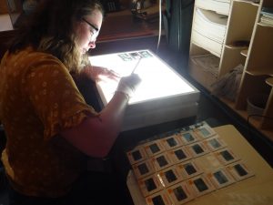 young woman looking at thumbnail print images over a lightbox