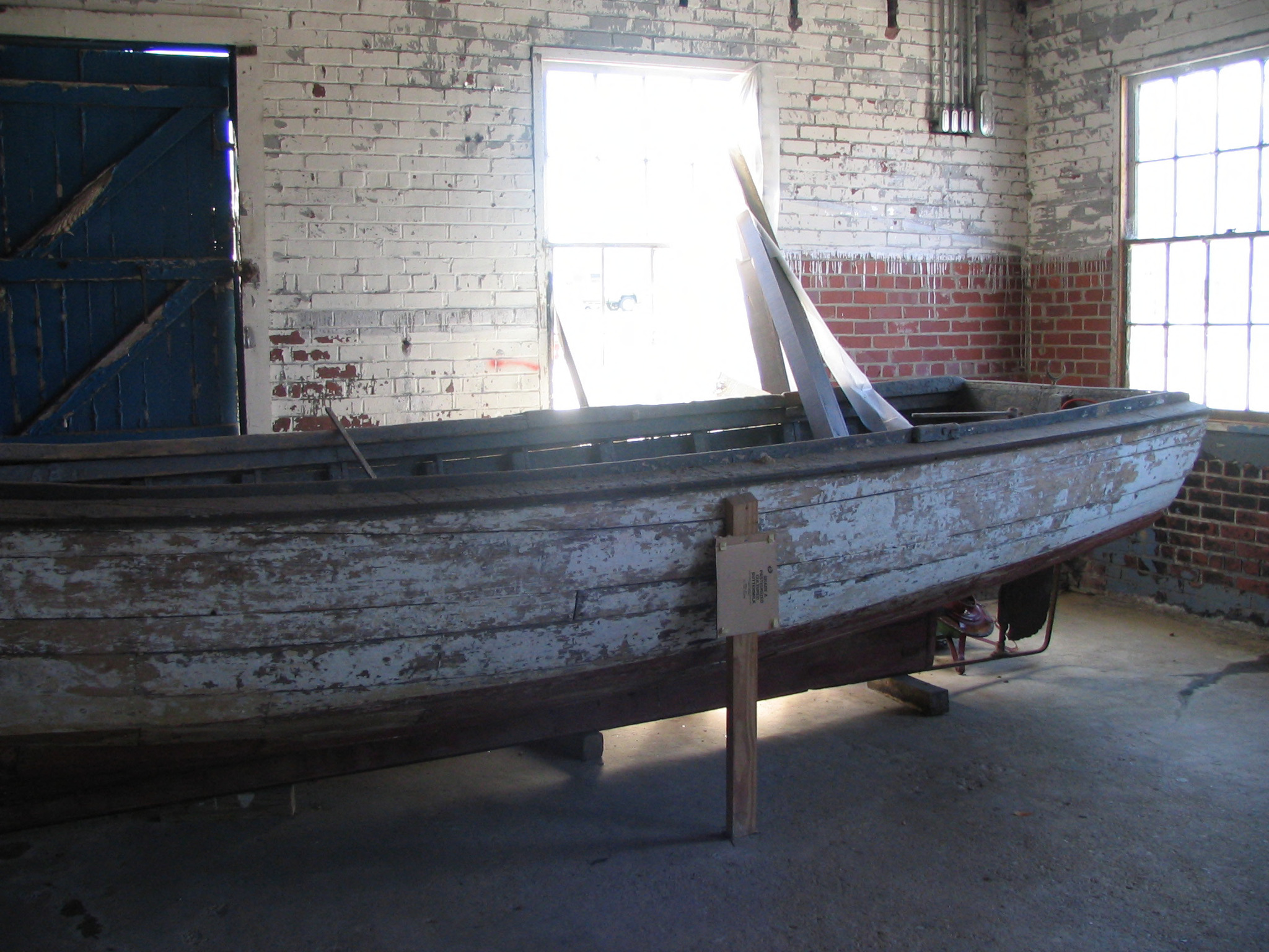 old wooden boat sitting on a frame in an empty room